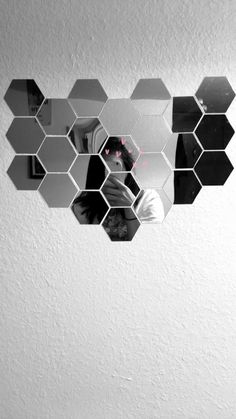 the reflection of a woman in a mirror is shown with hexagonal mirrors above her