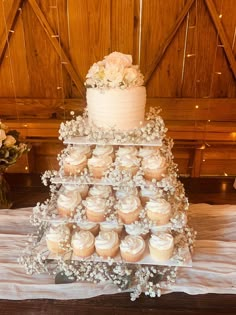 a wedding cake and cupcakes on a table