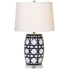 a table lamp with a white shade on it and a black geometric design in the middle