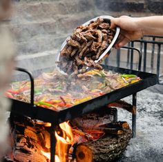 a person is cooking food over an open fire