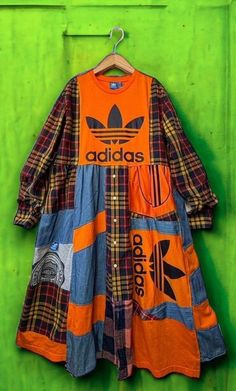 an adidas shirt hanging on a green wall