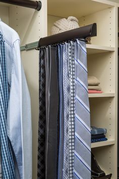 several ties are hanging on a rack in a closet