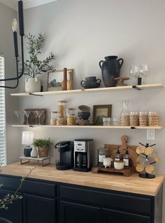 a kitchen counter with coffee maker and cups on it