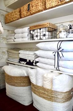 stacks of white linens are stacked on shelves