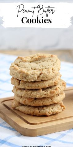 a stack of peanut butter cookies sitting on top of a wooden cutting board