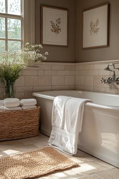 a white bath tub sitting next to a window with flowers in the vase on it