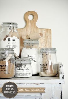 some jars are sitting on a shelf next to a cutting board