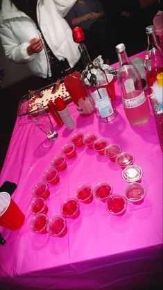 a pink table topped with lots of drinks