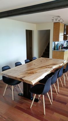 a large wooden table sitting in the middle of a room with blue chairs around it