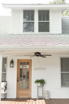 a white house with a fan on the front porch