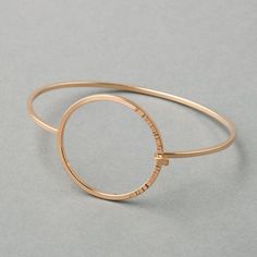 A high-polish bangle made with square wire bands, featuring a circular closure with a hammered texture one third of the way around. - Tension-connection closure- Circle measures 1 ¼” wide- 2mm thick bandSequence Collection Modern Hammered Yellow Gold Bracelets, Modern Rose Gold Bangle, Modern Rose Gold Round Bangle, Modern Hammered Bangle Bracelets, Modern Hammered Yellow Gold Bangle, Modern Hammered Open Circle Jewelry, Modern 14k Gold Hoop Bracelets, Modern Hammered Bangle For Formal Occasions, Modern 14k Gold Hoop Bangle