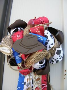 this is a wreath made out of fabric and burlocks with cowboy hats on it