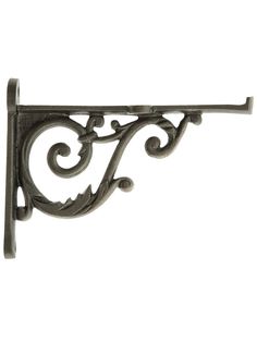 an ornate metal shelf bracket with scrolls and leaves on the top, against a white background