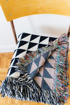 a black and white blanket sitting on top of a wooden chair