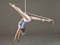 a woman hanging upside down on a rope