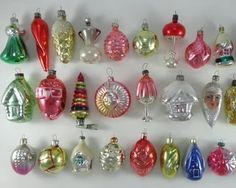 a collection of glass christmas ornaments, all in different colors and sizes on a white background