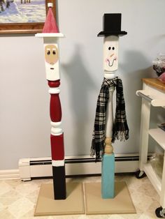 two wooden poles made to look like people in hats and scarfs