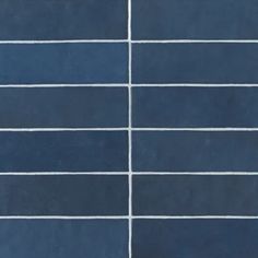 a blue tiled wall with white lines painted on the tiles in different colors and sizes