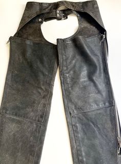 Vintage faded black leather chaps with a worn & rugged patina Made in USA by Brooks Leather Sportswear Measurements: Waist: adjustable from about 33-1/2" to 39" Thigh (laying flat & measured across):  10-3/4" Knee (laying flat & measured across): 9-1/2" Inseam (taken from top of back thigh as shown in photos): 31" Good vintage condition with overall aging, discoloration, distressing and water spots.  There is no doubt these guys have been well loved over the years! A NOTE ABOUT MY CLOTHING LISTINGS: I'm very picky when it comes to cut and style so you can rest assured my vintage garments will be WEARABLE mixed in with your modern wardrobe.  I only source high-quality pieces in good to excellent condition and bring them to you at a REASONABLE price.  Unless otherwise noted, all garments are American Vintage Clothing, Riding Chaps, Leather Chaps, Western Clothes, Water Spots, Modern Wardrobe, Vintage Western, Black Vintage, Adjustable Belt