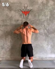 a man standing in front of a wall with his back to the camera and hands behind his head