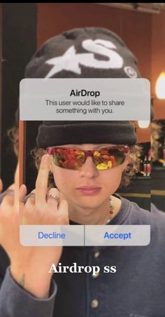 a woman wearing sunglasses and a hat holding up her cell phone to show the screen