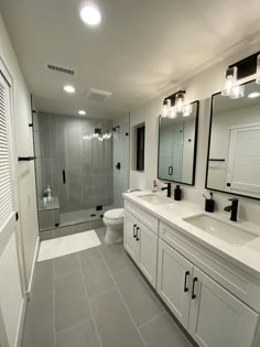 a bathroom with two sinks, a toilet and a walk in shower