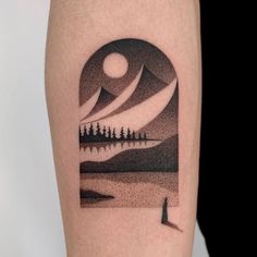 a man's arm with a landscape tattoo on it