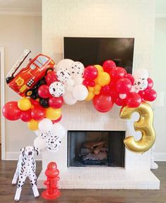 the balloon arch is decorated with cars, firetrucks and balloons for a birthday party