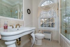 a bathroom with a toilet, sink and shower in it's own home area