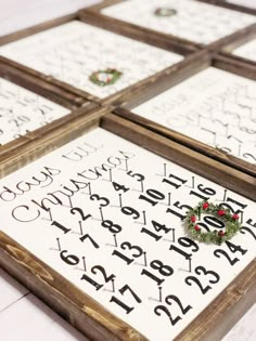 four wooden frames with numbers and holly wreaths on the top one is decorated in black, white and red