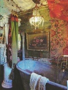 an old fashioned bathtub in a bathroom with floral wallpaper and chandelier