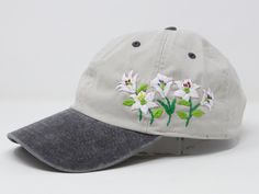 a baseball cap with white flowers embroidered on the front and grey brimmed visor