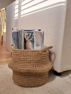 a basket with magazines in it sitting on the floor