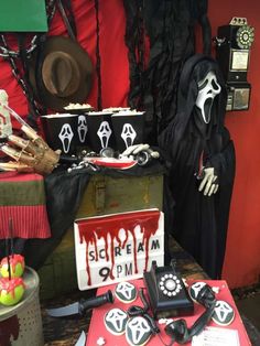 a table topped with lots of halloween items and decorations on top of a red table cloth