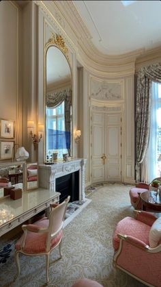 an elegant living room with pink chairs and mirrors