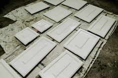 a bunch of white cabinet doors sitting on top of a table next to each other