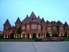 a large brick building with lots of windows and lights on it's front lawn