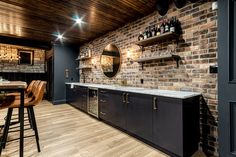 a bar with wooden floors and brick walls, surrounded by barstools and stools