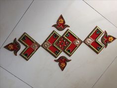 some red and gold designs on a white surface with other items in the corner to be seen