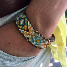 a close up of a person wearing a bracelet with beads on their arm and wrist