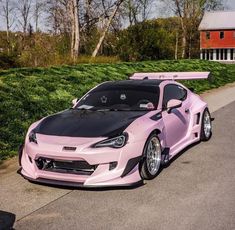 a pink sports car parked on the side of the road