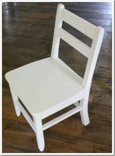 a white wooden chair sitting on top of a hard wood floor