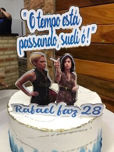 there is a cake with two women on it and one woman pointing at the camera