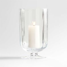 a white candle in a clear glass vase