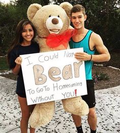 a man and woman pose with a teddy bear holding a sign that says i could not bear to go to homeowning without you