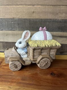 a wooden toy car with a bunny sitting in it