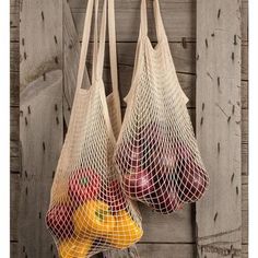 two bags filled with fruit hanging from hooks