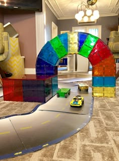 a toy car is parked in front of an arch made out of lego blocks on the floor