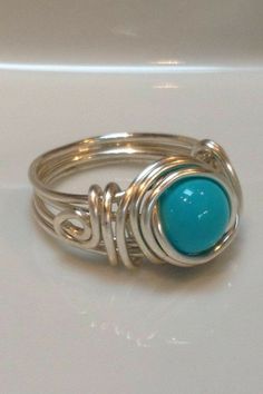 a silver ring with a turquoise stone on it