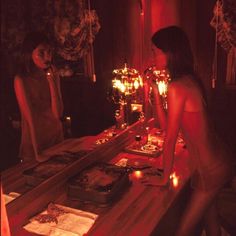 two women standing at a table with candles in front of them